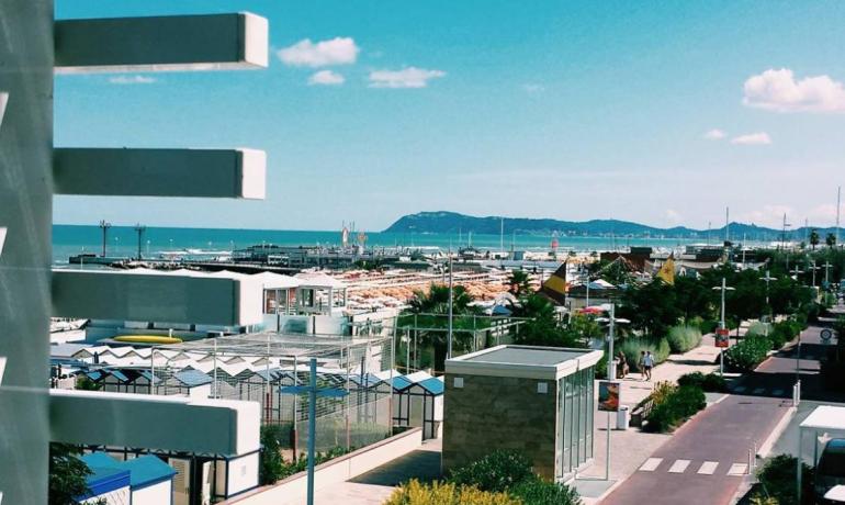 Vista sul mare con strutture moderne e cielo blu.