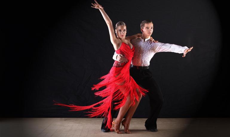 Coppia balla con eleganza in abiti da danza rossi e bianchi.