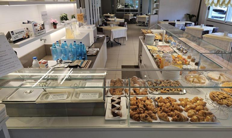 Abundant breakfast with pastries and drinks in a bright, elegant setting.